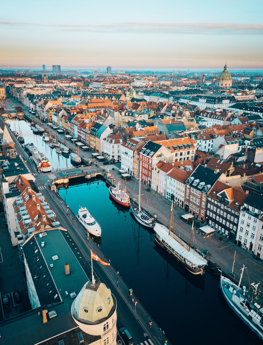 eSIM Denemarken aerial photo of boats in between concrete buildings during daytime