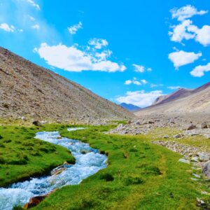 river in between brown mountains under blue sky during daytime